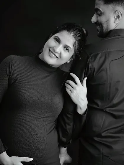 A sweet and candid black and white maternity shot capturing a genuine smile.
