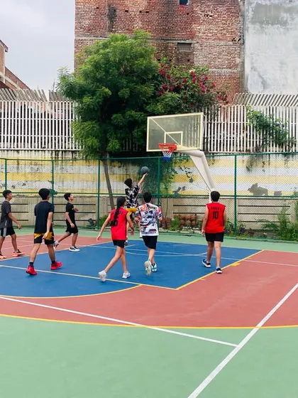 A senior player goes up for a shot in the paint during an evening session.