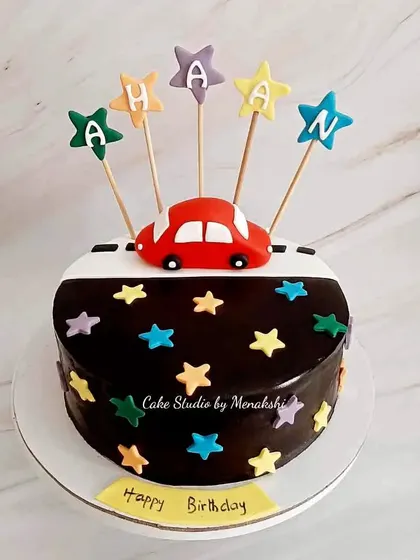 For Ahaan, who loves cars. This chocolate cake is decorated with a road, a little red car, and colorful stars with his name spelled out.