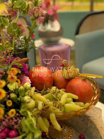 A close-up of a fruit and flower arrangement, showcasing the rich colors and textures.
