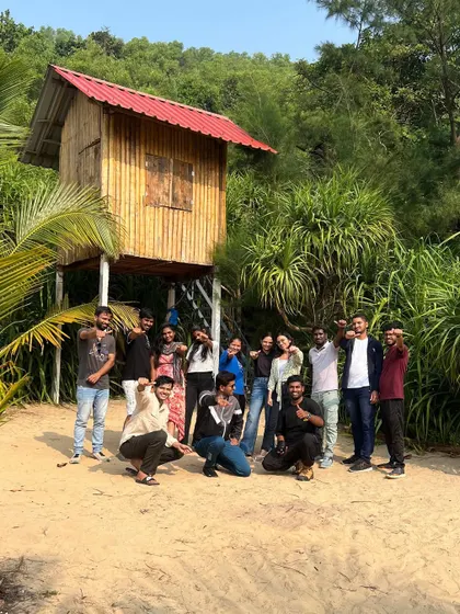 Our group posing in front of a cool treehouse on the beach, a unique find during our coastal exploration.