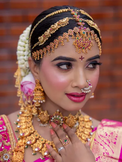 This close-up focuses on the matha patti and nose ring, essential elements of a traditional bridal look.