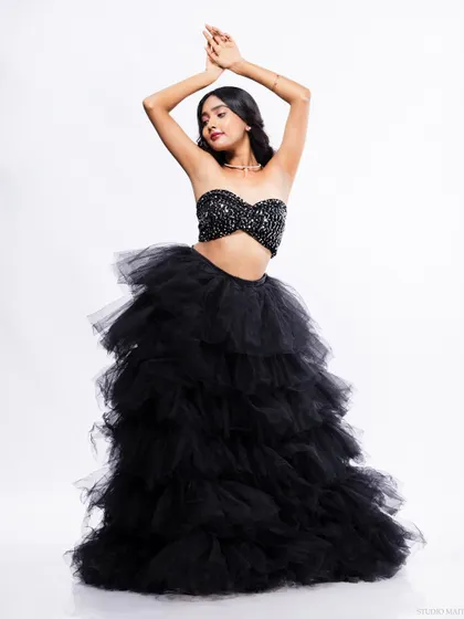 A full-length shot of a model in a dramatic black gown with a sequined top and a voluminous tulle skirt. This image is perfect for showcasing evening wear or a high-fashion editorial look.