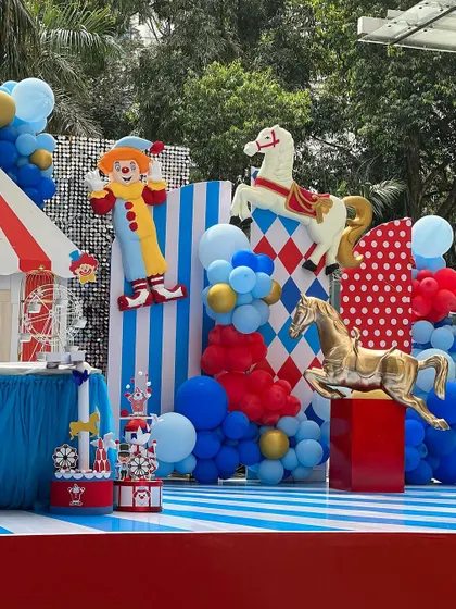 A wide view of the carnival birthday stage. The combination of the ticket booth, clown, and carousel horse against a backdrop of bold patterns and colors truly brought the circus to town.