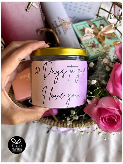 A personalized candle from the countdown hamper, with the message "30 Days to go! I love you."