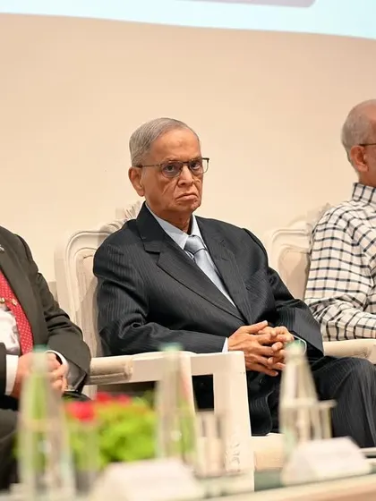 Shri Narayana Murthy seated on the dais with other dignitaries. I ensure to capture the key attendees and their engagement during the event.