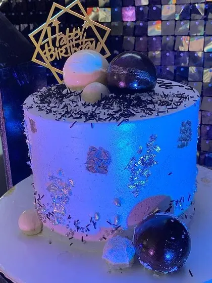 The stylish birthday cake for the 23rd birthday party, decorated with silver leaf and chocolate spheres to match the theme.