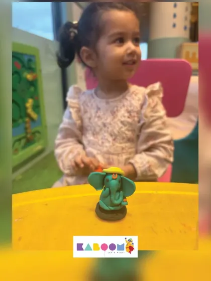The pure joy on a toddler's face as she looks at the colorful clay Ganesha she helped create. Our workshops are designed to be fun for even the youngest children.