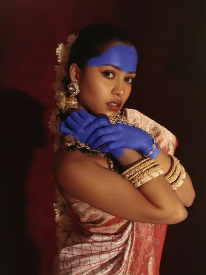 A gentle yet striking portrait from our conceptual series. The soft lighting and pose highlight the contrast between the traditional attire and the bold blue paint.