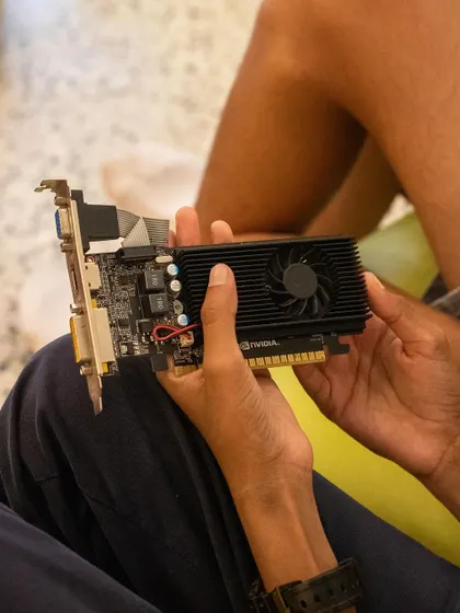 A student holds a graphics card, learning about its function and how it fits into the motherboard. We break down each component so kids understand the role it plays in the overall system.