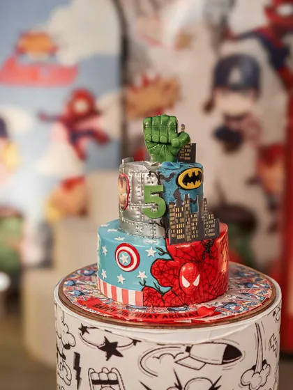 The centerpiece of the superhero party: an incredible themed cake featuring Batman, Spider-Man, Captain America, and the Hulk. The cake itself is a work of art.