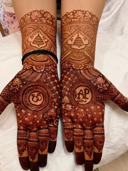 A close-up of the deep maroon stain on the personalized 'AP' engagement mehendi.