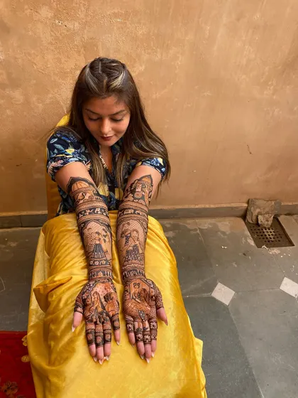 This bride is all set for her wedding festivities, showing off her intricate full-coverage mehandi. The design is packed with traditional motifs and portraits.