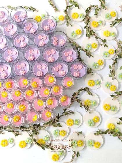 An assortment of mini jar candles and flower-adorned soy wax sachets, showcasing the variety available for custom gifts.