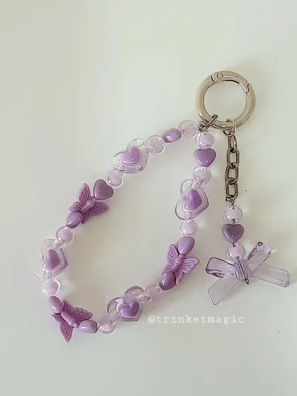A beautiful pastel purple version of my beaded charm, featuring butterflies, hearts, and a bow. It's the perfect accessory for a dreamy, lavender-themed look.