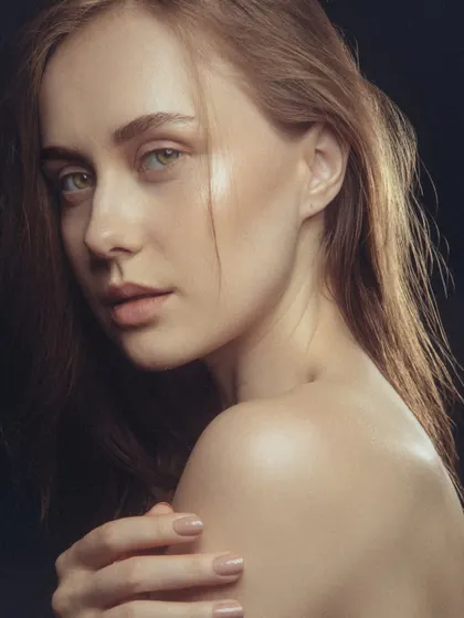 This pose showcases the beautiful, healthy-looking skin on the face and shoulders. The makeup is subtle and elegant.