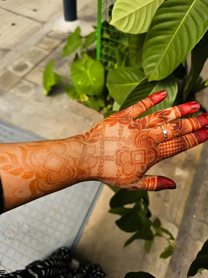 A lovely orange-red stain developing a few hours after paste removal. The design features a mix of geometric checks and delicate floral work on the forearm.
