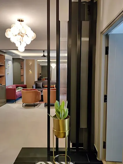 A vertical metal screen acts as a subtle partition between the foyer and the living area. This element adds a modern, graphic touch while maintaining a sense of openness.