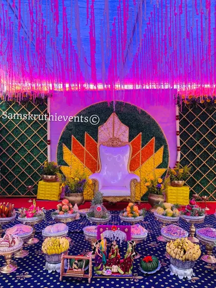 A creative lotus-themed backdrop with unique lighting for an evening ceremony. The blue and purple lights give the traditional setup a modern and magical feel.