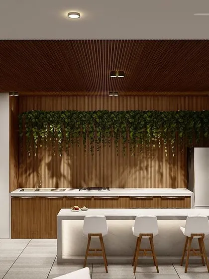 A view of the bar and kitchen area within the covered terrace lounge in Punjabi Bagh. The design uses a mix of wood paneling, marble countertops, and integrated lighting.