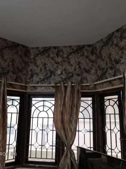 The dark floral wallpaper installed in a bay window area, showing how I handle complex angles and corners.
