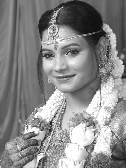 A classic black and white portrait of a bride in her traditional wedding attire, complete with a garland.
