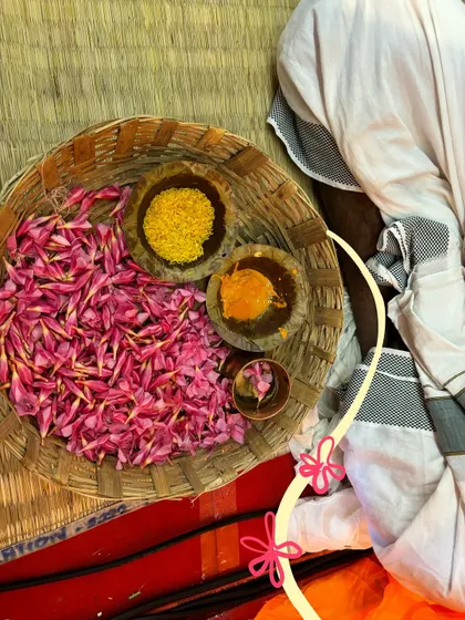 A close-up of the flower petals and powders for the pookalam, with a cute floral doodle to match.