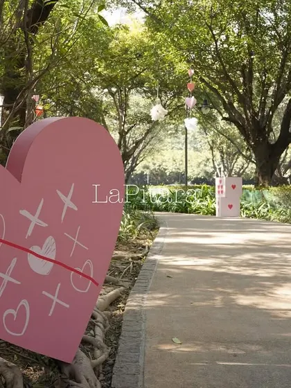 A large pink heart prop with a tic-tac-toe design of hugs and kisses.