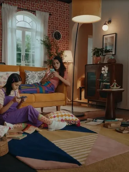 A wide shot of the living room scene from the Bullet Echo commercial. The colorful, slightly quirky styling of the two female characters adds to the playful vibe of the ad.