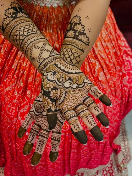 This design combines floral work with intricate check patterns. The dark fingertips provide a beautiful contrast, making the detailed work on the hands stand out.