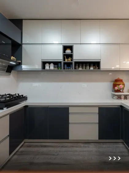 A full view of a U-shaped kitchen with a dual-tone grey and white theme. The open shelves in the upper cabinets provide a space for decor, adding a personal touch to the highly functional layout.