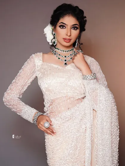 A full-view of the pearl-encrusted saree, paired with dramatic eye makeup and emerald jewelry.