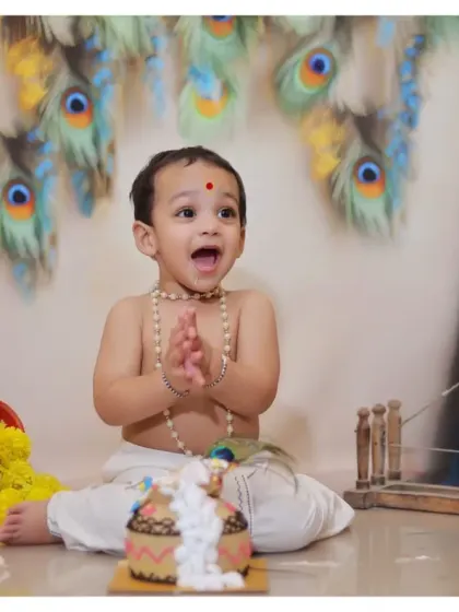 Celebrating a milestone with a Krishna-themed cake smash. This unique concept combines the fun of a birthday with the beauty of cultural tradition, complete with a 'dahi handi' style cake.