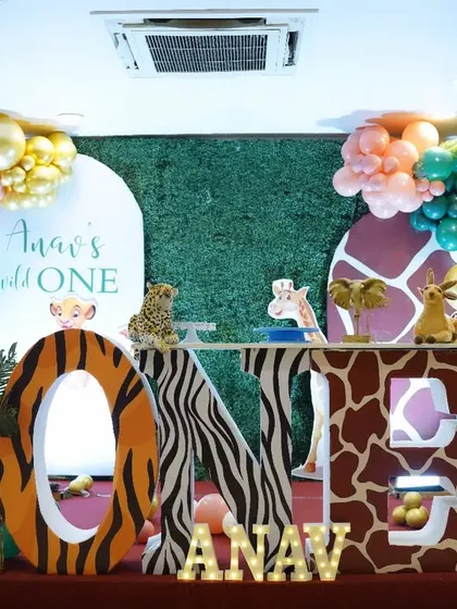 Anav's "Wild One" birthday was a jungle extravaganza. We used a greenery wall, animal print "ONE" letters, plush animal toys, and a colourful balloon garland to create a fun and friendly safari atmosphere.