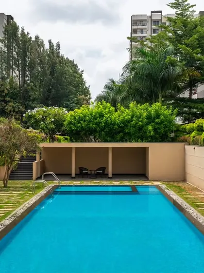 Here you can see how the landscape design provides a natural buffer between the residential blocks and the shared pool area. The sunken pool deck and raised planters create a sense of enclosure and tranquility, making it feel like a private resort.