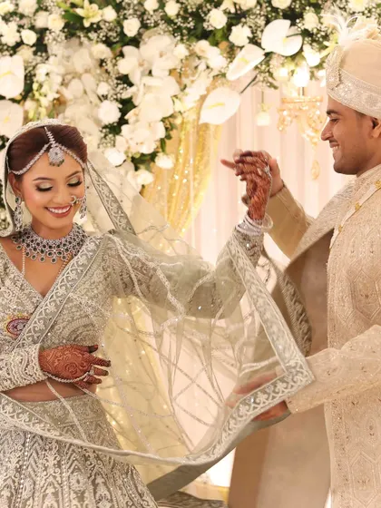 A candid, happy moment between the bride and groom. Her smile is infectious, and the diamond jewellery sparkles as she interacts with her partner.