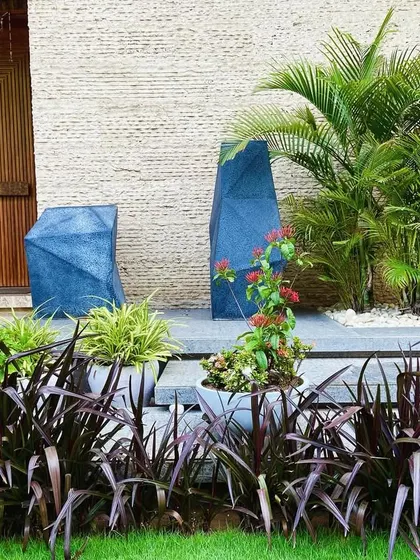 The combination of the textured stone wall, wooden door, and vibrant plants creates a rich and inviting entryway.