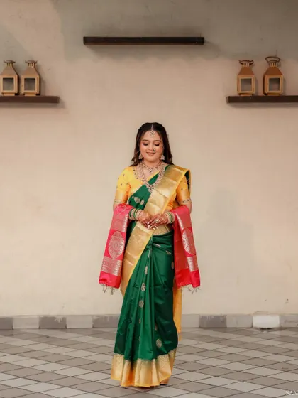 A full-length shot of a bride in a yellow and green saree, looking poised and ready for her ceremony.