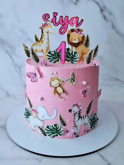 A pink jungle cake for Siya's first birthday. This design combines the popular jungle theme with a pretty pink color palette, using edible prints for a clean and vibrant look.