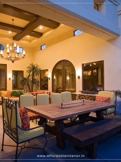 This spacious outdoor living and dining area is designed for entertaining, with a rustic wooden table and bench that complement the villa's architecture.