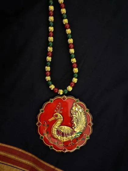The red peacock Tanjore pendant, a timeless piece that embodies grace and beauty.