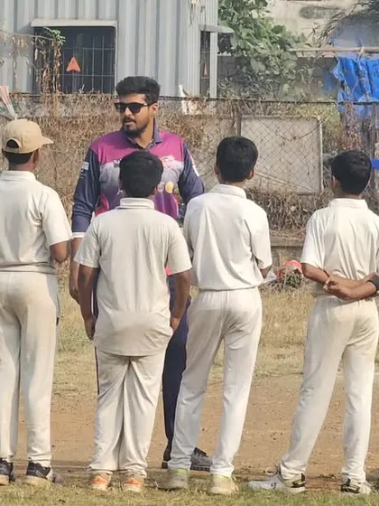 A coach gathers the team for a strategic talk during a match day. We focus on teaching game sense and tactics, not just physical skills.