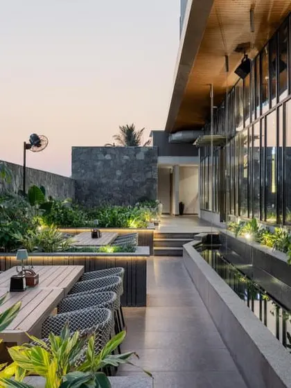 Sunken seating areas on the terrace are surrounded by lush planters and integrated lighting, creating intimate zones for dining.