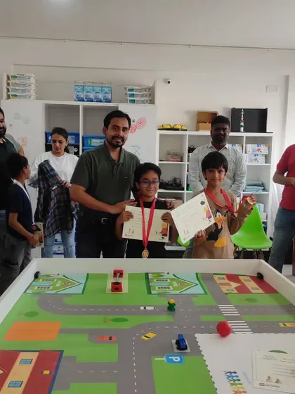 Proud parents look on as two students are awarded for their excellent performance in our internal robotics competition. We encourage family involvement in celebrating these milestones.