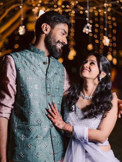 A candid moment between the couple at their reception, with the soft glow of fairy lights creating a romantic and intimate atmosphere.