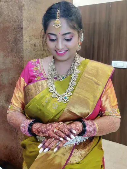 This image captures the beautiful, soft glam makeup with a focus on the eyes. The pink and gold tones on the eyelids perfectly match the details in her saree.