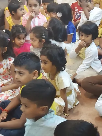Children dressed in festive yellow and white listen to a story about the arrival of spring. Our Vasant Panchami celebration is filled with color, stories, and creativity.