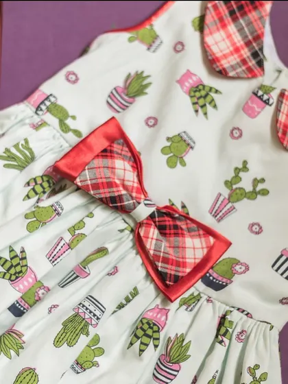 A closer look at the playful cactus print and the contrasting plaid bow. It’s a perfect example of how I love to mix patterns in a fun, stylish way.
