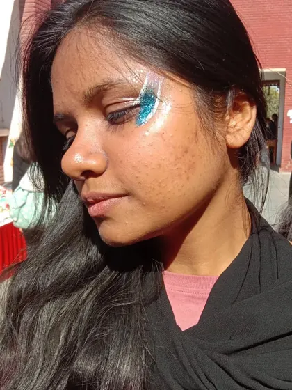 A swipe of bright blue glitter on the cheekbone. It's a simple design that makes a big statement.