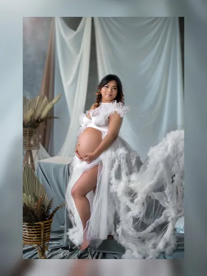 A full-length portrait showcasing a stunning, cloud-like tulle gown that makes the expecting mother look like she's floating on air.